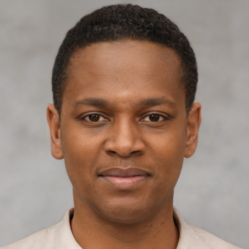 Joyful black young-adult male with short  brown hair and brown eyes