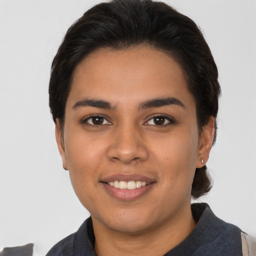 Joyful latino young-adult female with medium  brown hair and brown eyes