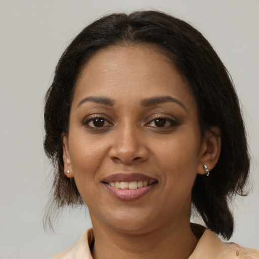 Joyful black young-adult female with medium  brown hair and brown eyes