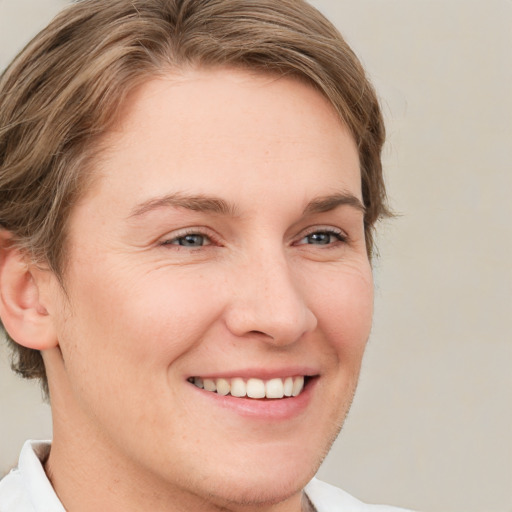 Joyful white young-adult female with short  brown hair and blue eyes