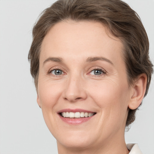 Joyful white adult female with medium  brown hair and grey eyes