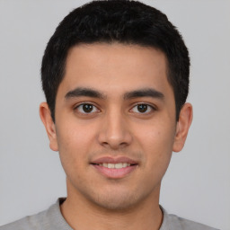 Joyful latino young-adult male with short  brown hair and brown eyes