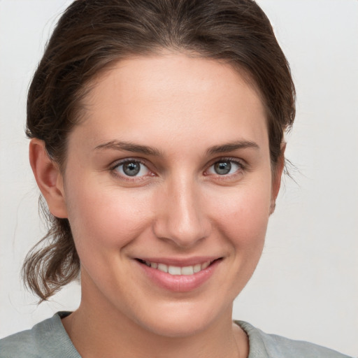 Joyful white young-adult female with medium  brown hair and grey eyes