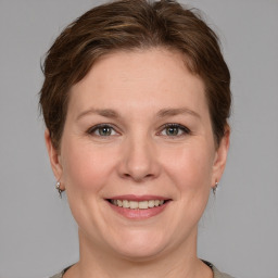 Joyful white adult female with medium  brown hair and grey eyes