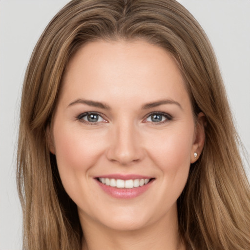 Joyful white young-adult female with long  brown hair and grey eyes