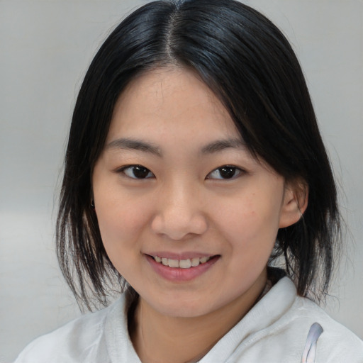 Joyful asian child female with medium  brown hair and brown eyes