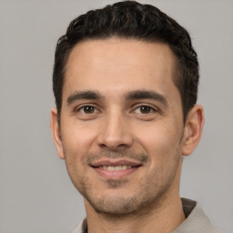 Joyful white young-adult male with short  black hair and brown eyes