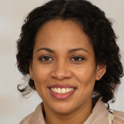 Joyful latino adult female with medium  brown hair and brown eyes