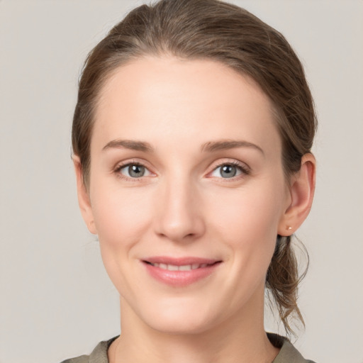 Joyful white young-adult female with medium  brown hair and grey eyes