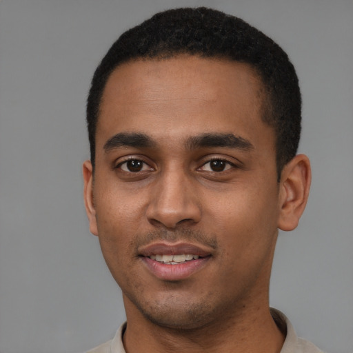 Joyful black young-adult male with short  black hair and brown eyes