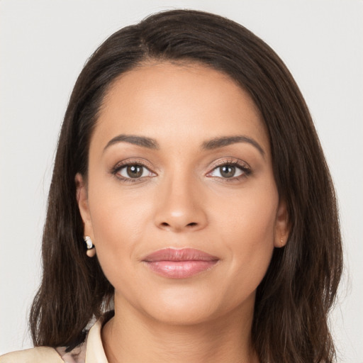 Joyful latino young-adult female with long  brown hair and brown eyes