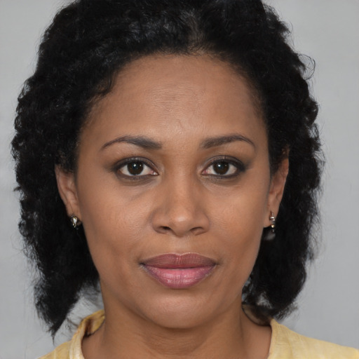 Joyful black adult female with medium  brown hair and brown eyes