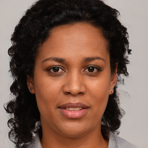Joyful black young-adult female with medium  brown hair and brown eyes