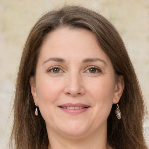 Joyful white adult female with long  brown hair and green eyes