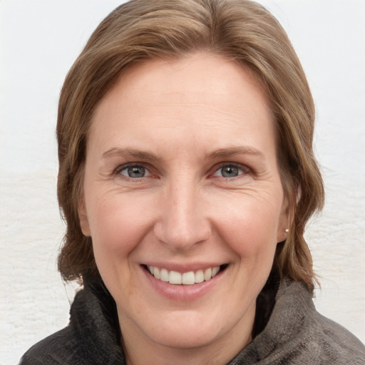 Joyful white adult female with medium  brown hair and grey eyes