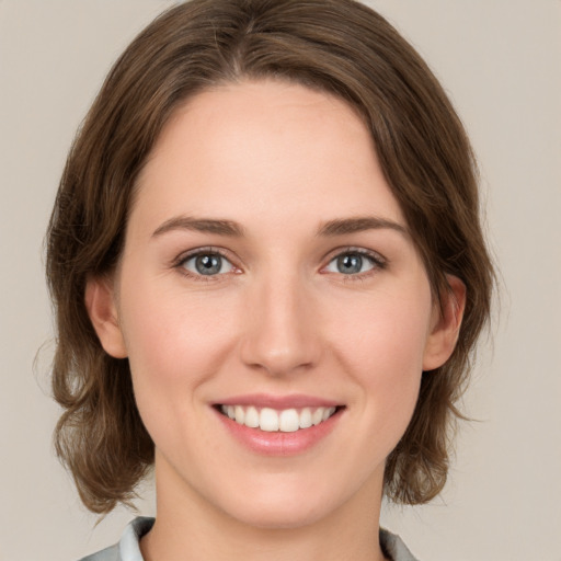 Joyful white young-adult female with medium  brown hair and green eyes