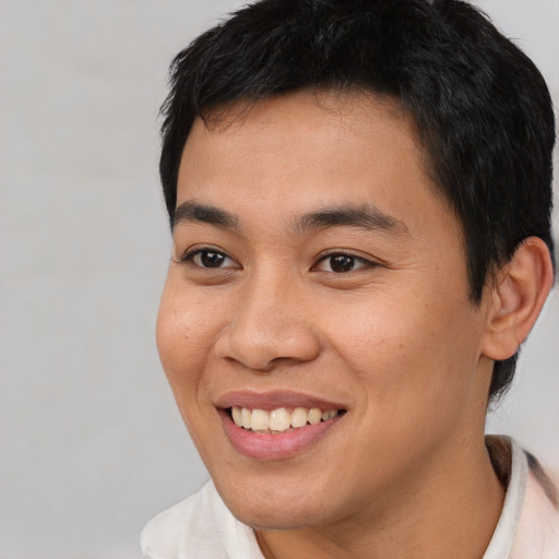 Joyful latino young-adult male with short  brown hair and brown eyes