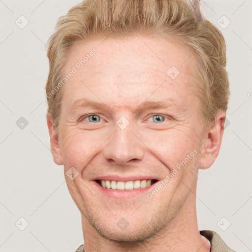 Joyful white adult male with short  brown hair and blue eyes