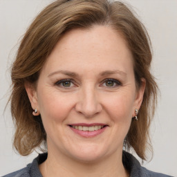 Joyful white adult female with medium  brown hair and grey eyes