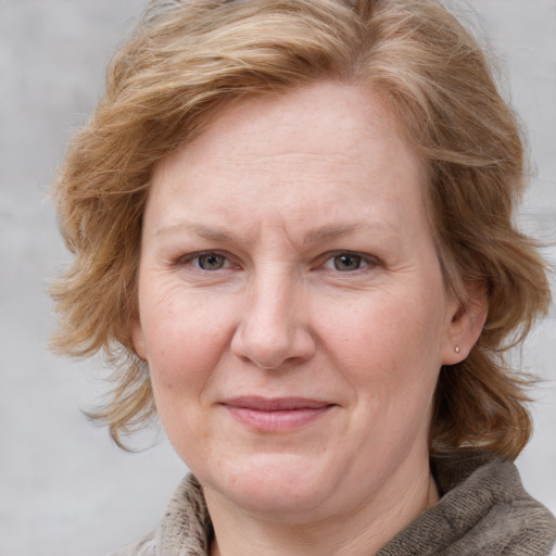 Joyful white adult female with medium  brown hair and blue eyes