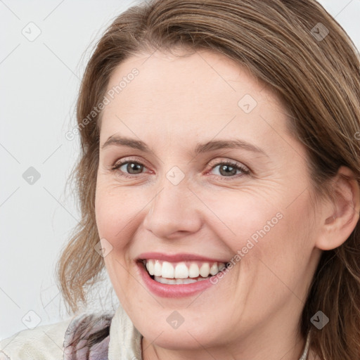 Joyful white young-adult female with long  brown hair and blue eyes