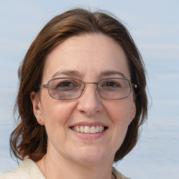 Joyful white adult female with medium  brown hair and blue eyes