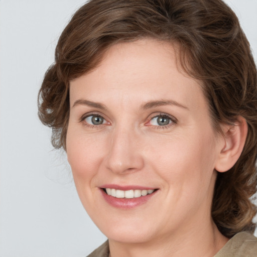 Joyful white adult female with medium  brown hair and grey eyes