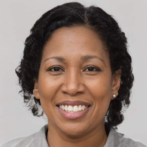 Joyful black adult female with medium  brown hair and brown eyes