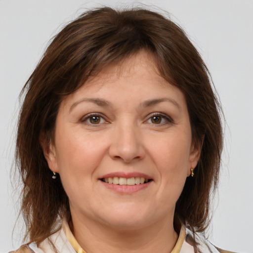 Joyful white adult female with medium  brown hair and brown eyes