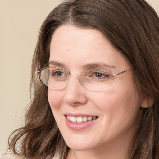 Joyful white adult female with long  brown hair and grey eyes