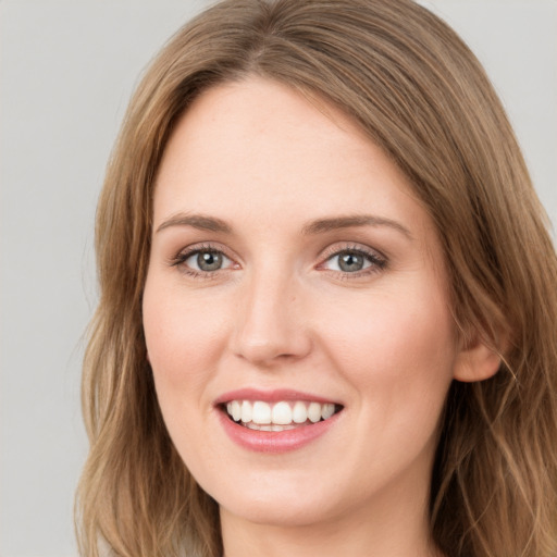 Joyful white young-adult female with long  brown hair and green eyes