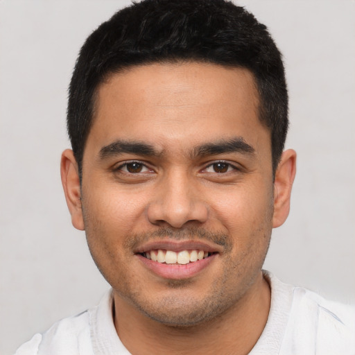 Joyful latino young-adult male with short  black hair and brown eyes