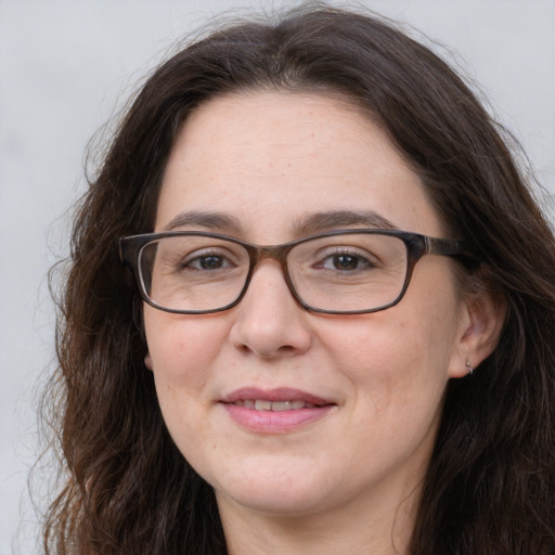 Joyful white adult female with long  brown hair and grey eyes