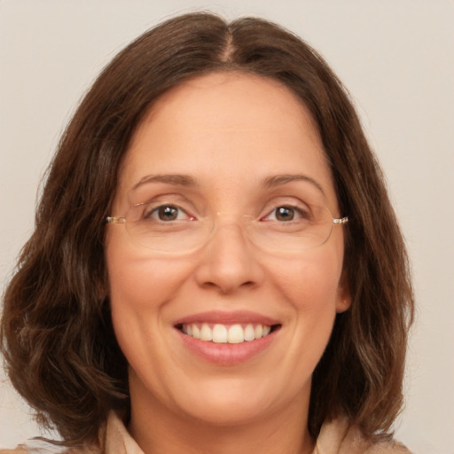 Joyful white adult female with medium  brown hair and brown eyes