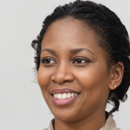 Joyful black young-adult female with medium  brown hair and brown eyes