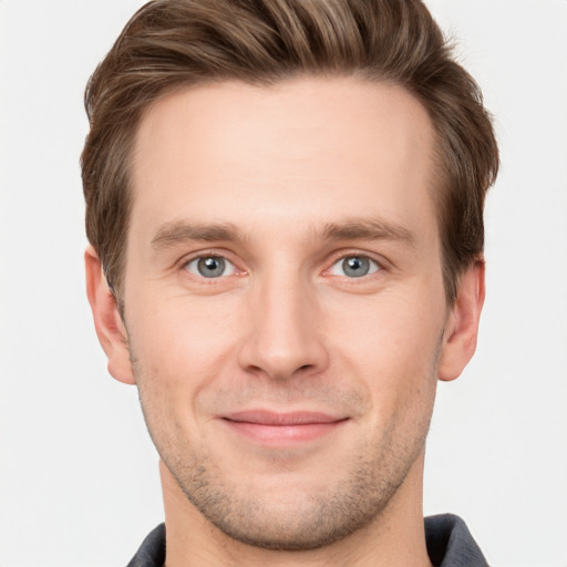 Joyful white young-adult male with short  brown hair and grey eyes