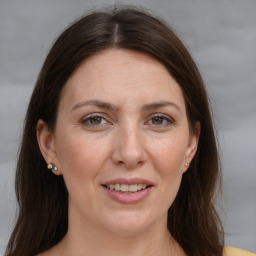 Joyful white adult female with long  brown hair and brown eyes