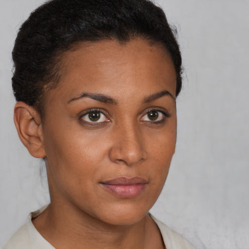 Joyful black young-adult female with short  brown hair and brown eyes