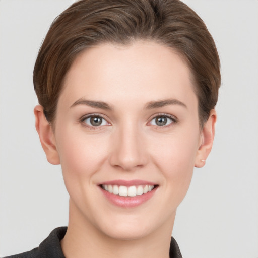 Joyful white young-adult female with short  brown hair and grey eyes