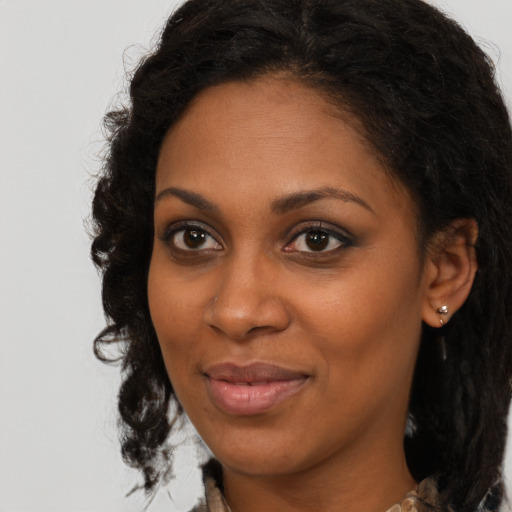 Joyful black young-adult female with long  brown hair and brown eyes