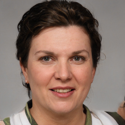 Joyful white adult female with medium  brown hair and blue eyes