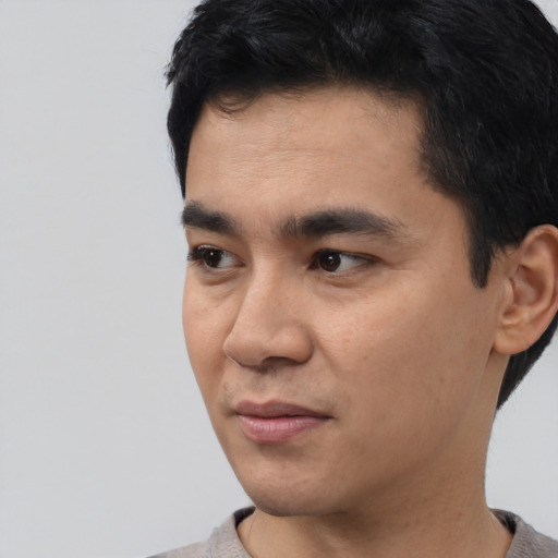 Joyful asian young-adult male with short  black hair and brown eyes