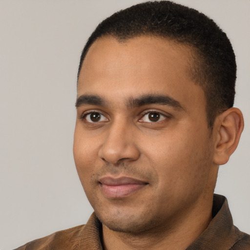 Joyful black young-adult male with short  brown hair and brown eyes