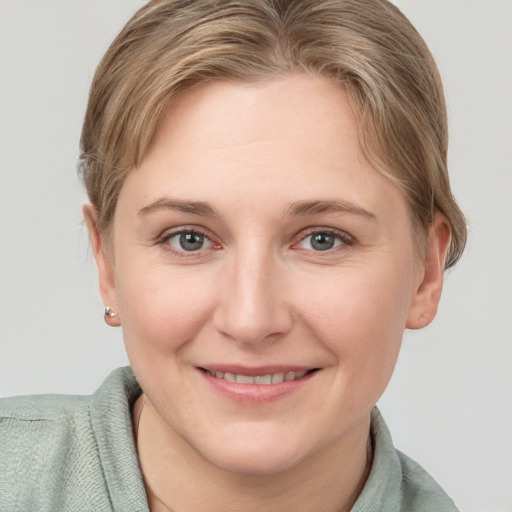 Joyful white young-adult female with short  brown hair and grey eyes