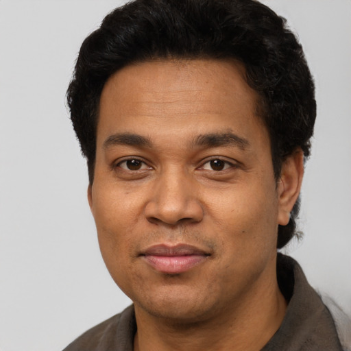 Joyful latino adult male with short  black hair and brown eyes