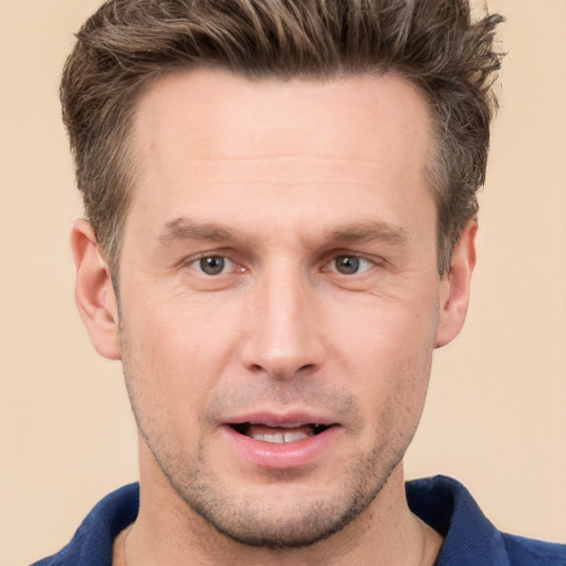 Joyful white adult male with short  brown hair and grey eyes