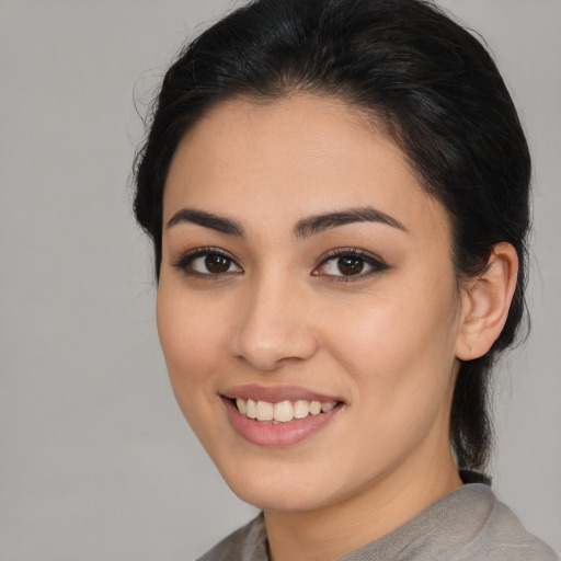 Joyful latino young-adult female with medium  brown hair and brown eyes