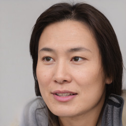 Joyful asian adult female with medium  brown hair and brown eyes