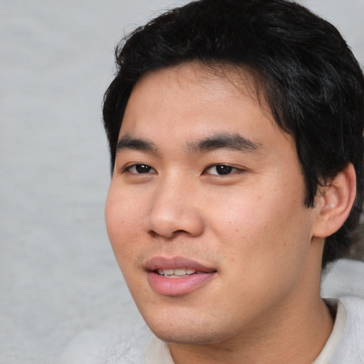 Joyful asian young-adult male with short  black hair and brown eyes