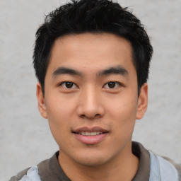 Joyful asian young-adult male with short  black hair and brown eyes